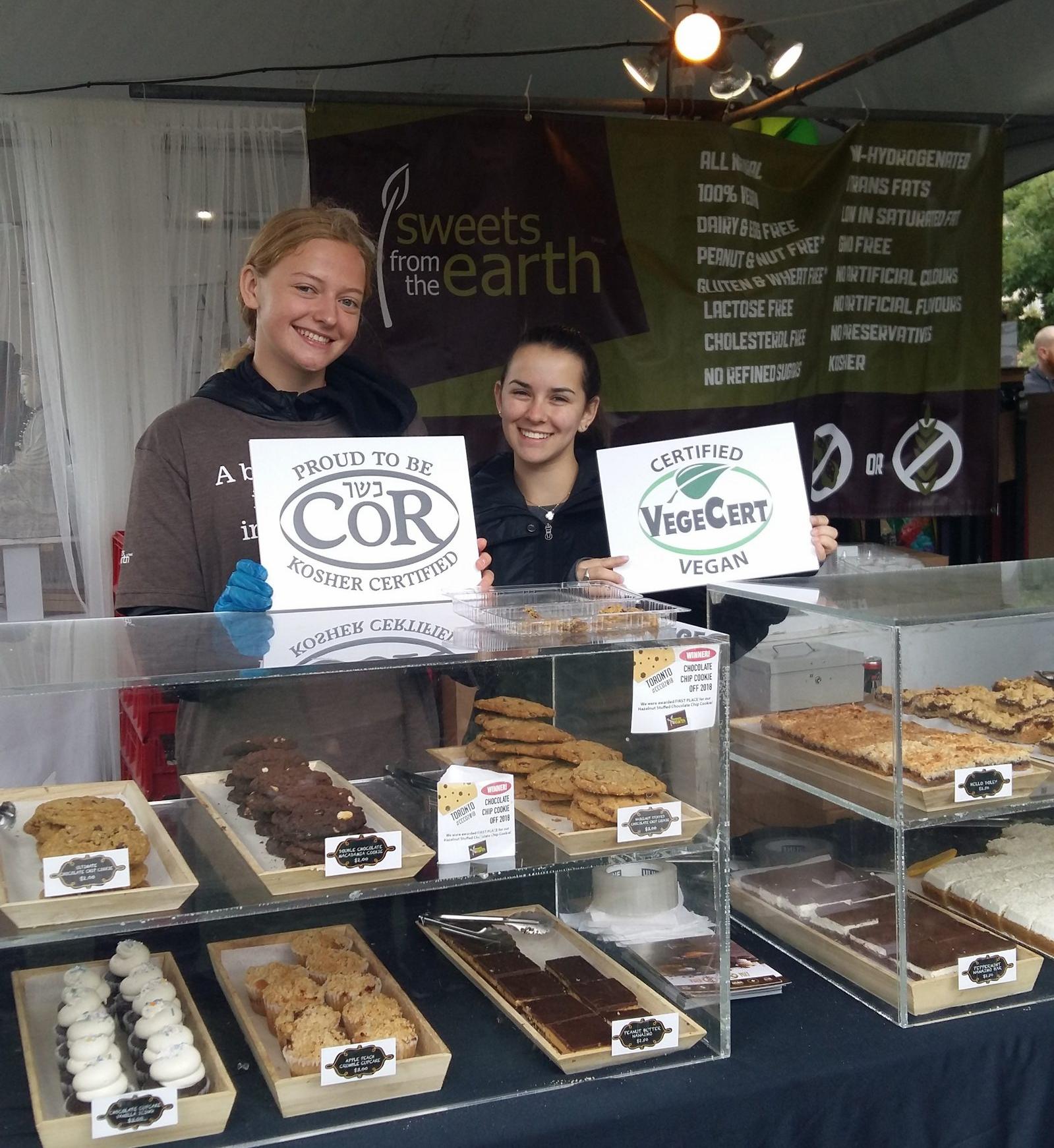 VegeCert team members at a trade show displaying Certified Vegan signage